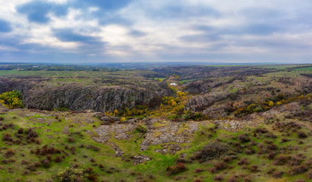 A stream flows in the Aktovsky Canyon, Ukraine. Autumn trees and large stone boulders around. Aerial panoramic drone shotの写真素材