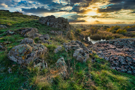 Beautiful small river among large stones and green vegetation on the hills in Ukraineの写真素材