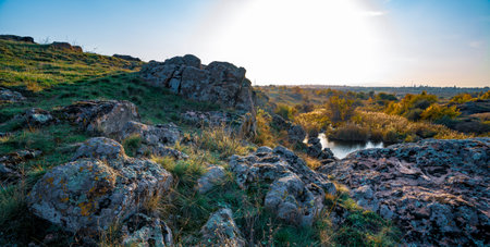 Beautiful small river among large stones and green vegetation on the hills in Ukraine