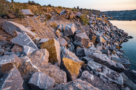 A very small beautiful lake surrounded by large heaps of stone waste from hard work in the mineの写真素材