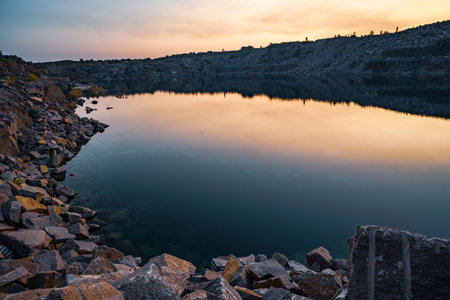 A very small beautiful lake surrounded by large heaps of stone waste from hard work in the mineの写真素材