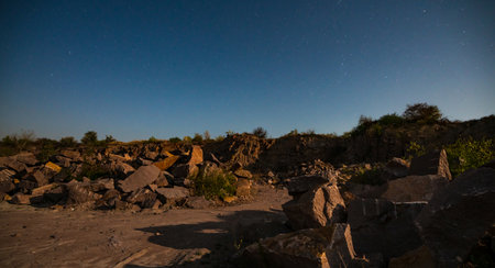 Beautiful lake surrounded by large piles of stone waste from hard work in a mine against a beautiful...