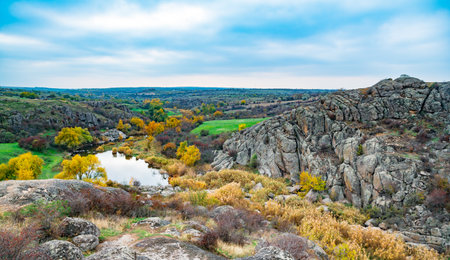 Huge deposits of old stone minerals covered with vegetation in a meadow filled with warm sun in Ukraine and its beautiful natureの写真素材