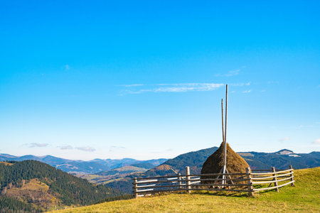 A large haystack against the backdrop of the wonderful nature of the Carpathians and the extraordinary skyの写真素材
