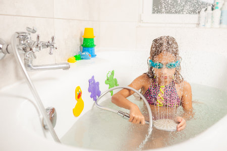 Emotional funny girl joyfully plays with water