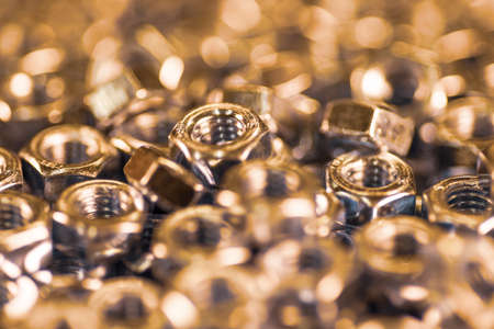 Close-up metal chrome nuts in a chaotic order. Background concept for fasteners and construction topics. Repair and spare parts conceptの写真素材