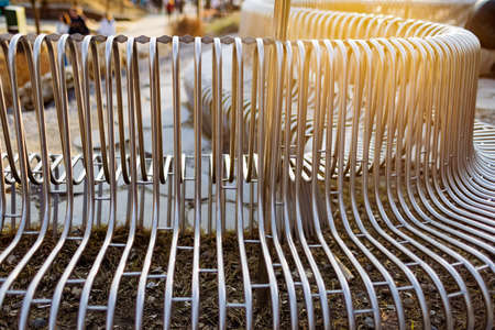 Close-up street bench metal pipes arranged parallel to each other on a street structure. Concept for weather resistant materials and modern industrial design. Advertising spaceの写真素材