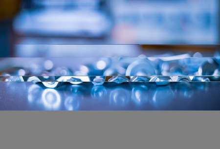 Metal chrome bolts and nuts in a chaotic order industrial background