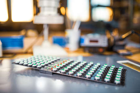 Close-up of a LED panel of green light indicators is in the production of automatic control systems....