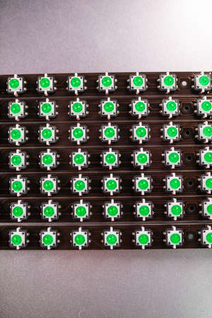 Close-up of a LED panel of green light indicators is in the production. The concept of industrial...