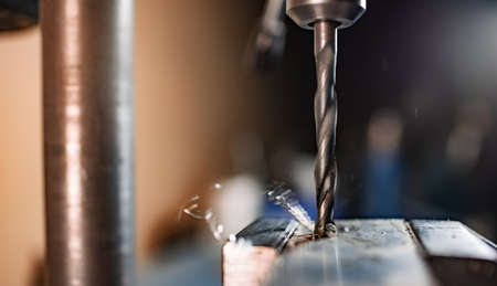 Drilling process with shavings close-up at the workplace in workshop