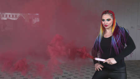 A girl in a simple black dress with colored braids