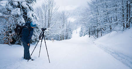 The photographer shoot a mountain forest in the Carpathians in rainy and snowy weather