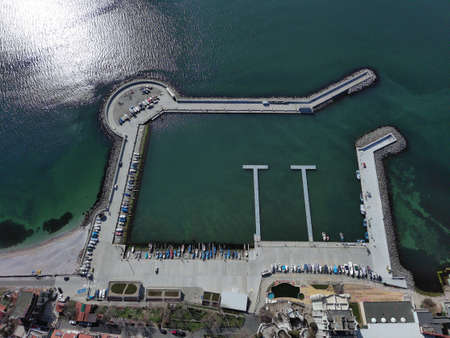 Birds-eye view of a small newly built deck of a small resort ancient town - the peninsula of Pomorie with many different modern boats and boats, in the big salty calm Black Seaの写真素材