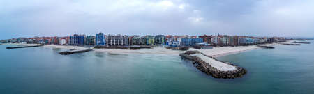 Panoramic bird's eye view over small ancient resort town of Pomorie with old European small houses and quiet calm empty streets, washed by the sea spring turquoise Black Sea on clear day in Bulgariaの写真素材