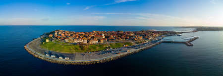 Bird's eye view panorama of the small spring green town of Nessebar with historic ancient European houses and fresh blooming empty parks, washed by the calm porous deep Black Sea in Bulgariaの写真素材