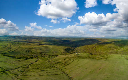 Bird's eye view panorama of spring blooming green meadows and wooded hilly slopes of the Balkan...