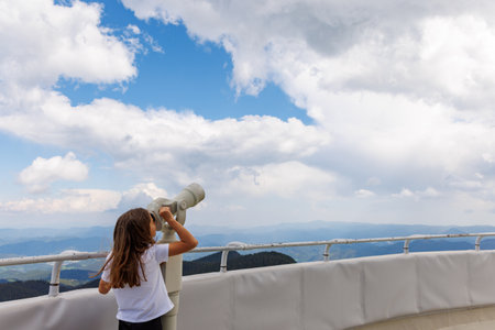 Curious little girl looking at landscapes of mountain forest valley of Rhodope Mountains and bright...