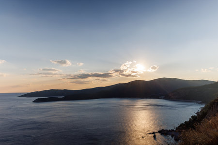 Dazzling sun in the evening sky illuminates all the peaks of the Balkan Montenegrin mountains and...