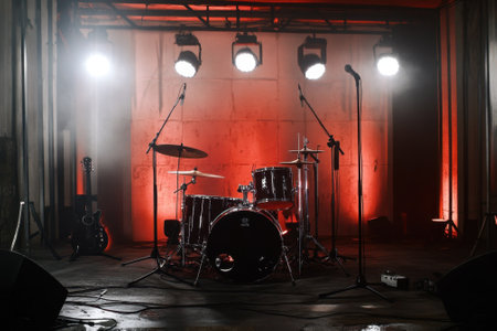 Lighting creates an energetic atmosphere around the empty drum set waiting for musicians to start playing.の写真素材