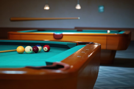 A quiet game room with two pool tables featuring colorful balls, inviting players for a friendly match.の写真素材