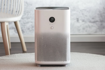 A sleek air purifier sits on a soft rug in a bright room, showing modern design and functionality.の写真素材