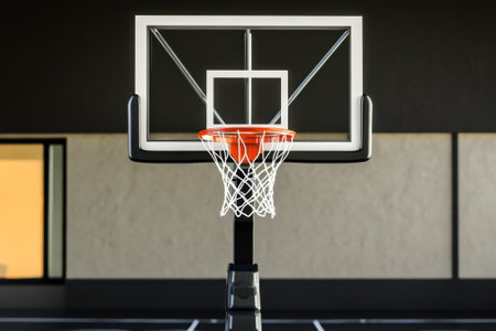 A basketball hoop stands prominently on a modern court with soft twilight light illuminating the space.の素材