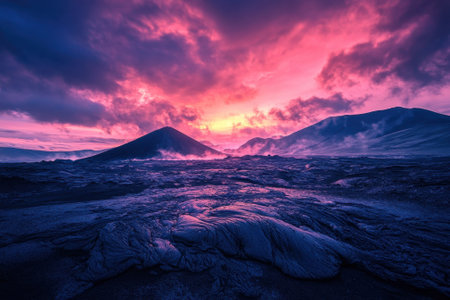 Vibrant sunset light illuminates the volcanic mountains and lava fields creating a breathtaking atmosphere.の写真素材