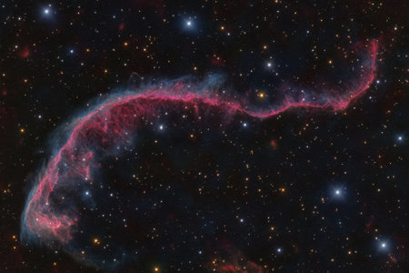 A vibrant cosmic nebula winds through a dark expanse filled with stars, showing interstellar beauty.の写真素材