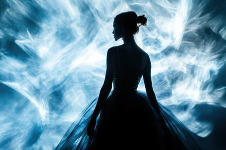 A graceful dancer poses in a flowing gown against a captivating blue backdrop, creating an ethereal vibe.の写真素材