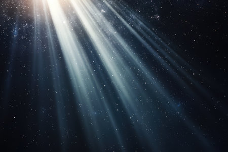 Radiant beams of light penetrate through the dark night, revealing a starry expanse above.の写真素材