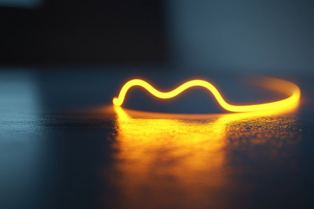 A glowing line of orange light creates wavy patterns on a shiny surface, giving a serene atmosphere.の写真素材