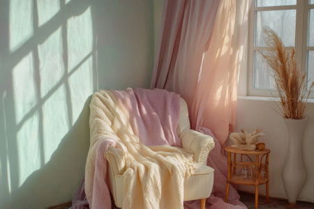 Soft morning light creates a tranquil ambiance in a corner with a cozy chair, blankets, and decorative elements.の素材