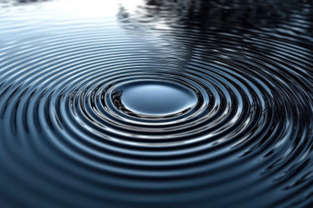 Gentle ripples expand across still water, reflecting soft light while creating a soothing atmosphere.の写真素材