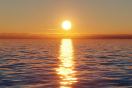 A vibrant sunset casts warm gold and orange tones on calm ocean waters, creating a serene evening atmosphere.の写真素材