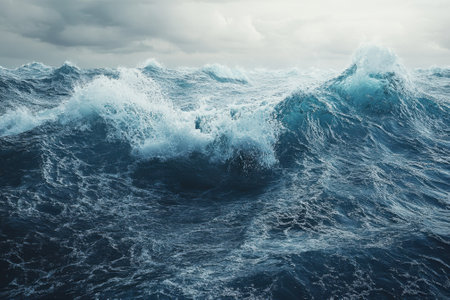 Turbulent waves surge against one another, reflecting the dim light of twilight while clouds gather above.の写真素材