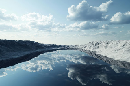Calm water reflects fluffy white clouds in a stark, open terrain under a clear sky.の写真素材