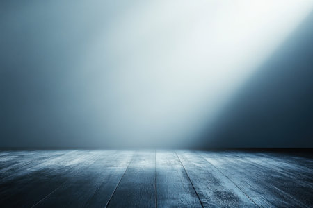 Soft light streams onto a dark wooden floor creating a serene and minimalist atmosphere.の写真素材