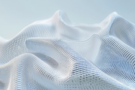 Gentle white fabric cascades softly, showcasing textures in a calming, softly lit environment.の写真素材
