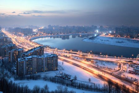 City skyline glows as lights reflect on a frozen river under a dusky winter sky.の写真素材