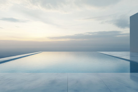 An infinity pool reflects the peaceful sky at sunset, creating a tranquil atmosphere by the water's edge.の写真素材