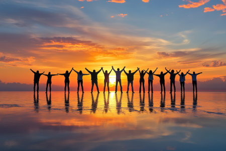 A joyful group stands together on the beach at sunset, capturing a moment of camaraderie and fun.の写真素材