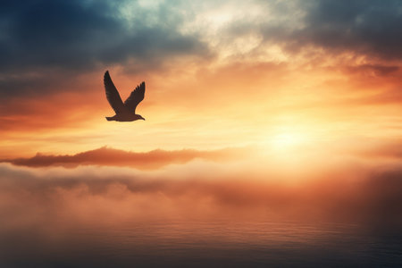 A bird glides gracefully through a colorful sunset, while soft clouds hover above tranquil waters.の写真素材