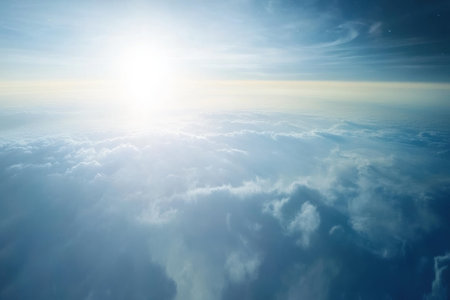 Glowing sunlight shines over soft clouds, creating a peaceful atmosphere on a clear day.の写真素材