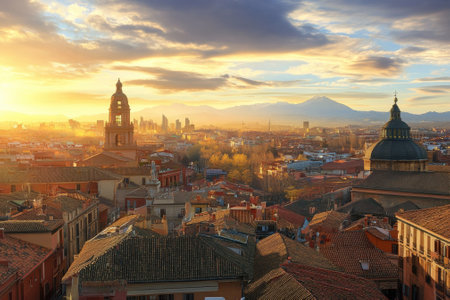 Sunlight bathes Madrid's rooftops with a stunning view of mountains as the day transitions to evening.の写真素材