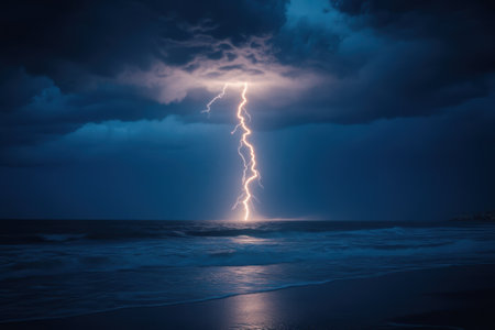 Lightning illuminates the turbulent ocean waves as dark clouds gather in the night sky.の写真素材
