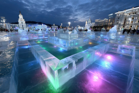 Visitors admire brilliant ice structures glowing with colored lights at a winter festival in the city.の写真素材