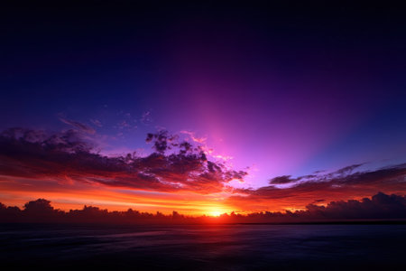 Stunning sunset lights up the sky with purple and orange shades above the serene ocean waters.の写真素材