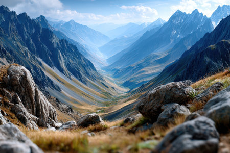 A vast mountain valley stretches out under a blue and cloudy skyの写真素材
