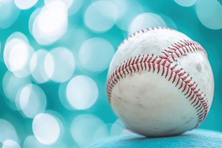 A close-up of a baseball resting on a surface with a shimmering turquoise background, evoking a lively atmosphere.の写真素材